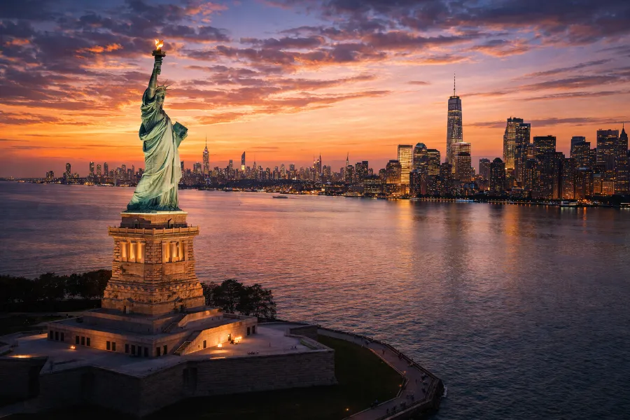Statue of Liberty and New York skyline at sunset